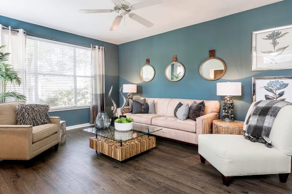 a living room with blue walls and a ceiling fan at Fortress Grove, Murfreesboro