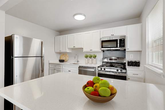 A kitchen with a bowl of fruit on the counter.