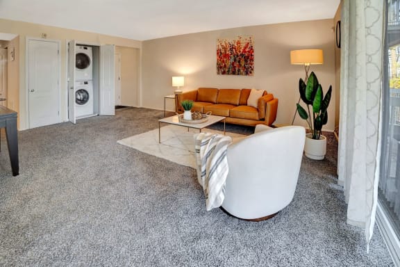 a living room with a couch coffee table and a washer and dryer, Kenilworth at Charles Apartments, Towson, MD