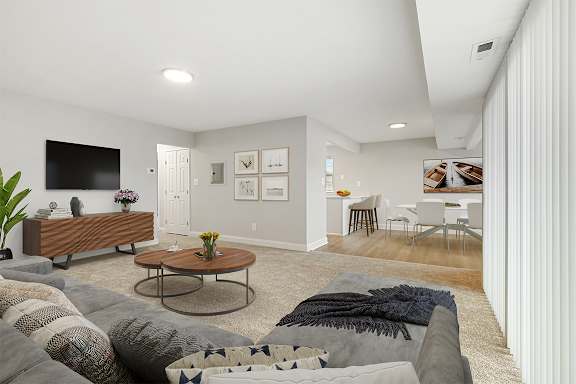 A living room with a grey couch and a wooden coffee table.