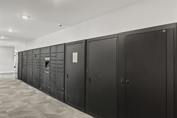 a row of black lockers in a room with white walls and a tile floor at Central Island Square, Daniel Island, 29492
