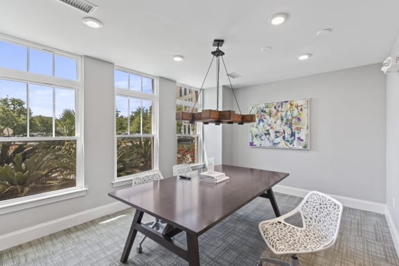 a dining room with a table and chairs and windows at Central Island Square, Daniel Island, SC