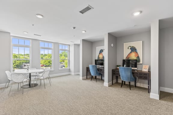 a living room with a table and chairs and a desk and windows at Central Island Square, Daniel Island, South Carolina