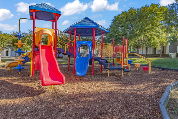 a playground with a red slide and a blue slide at Fortress Grove, Tennessee