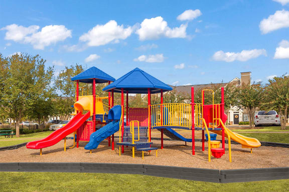 a playground with a blue roof and yellow and red slides at Fortress Grove, Tennessee