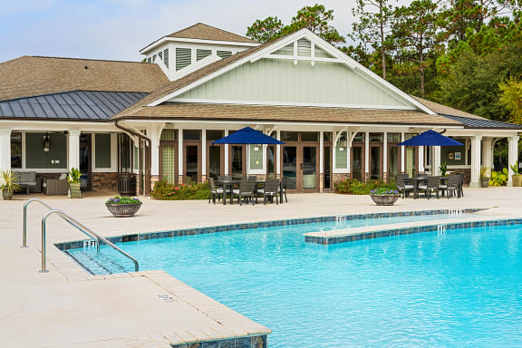 Pool with clubhouse and picnic tables at The Reserve at Mayfaire Apartments, Wilmington NC