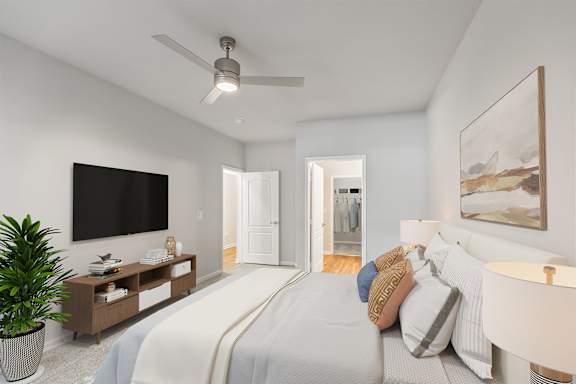 A bedroom with a large bed and a flat screen TV mounted on the wall at Sweetgrass Landing, Mount Pleasant, SC