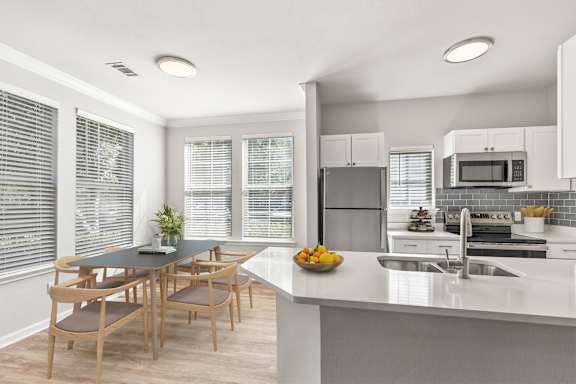 A modern kitchen with a dining table and chairs at Sweetgrass Landing, Mount Pleasant, SC