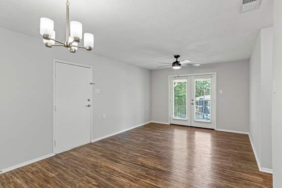 A room with a wooden floor and a ceiling fan.