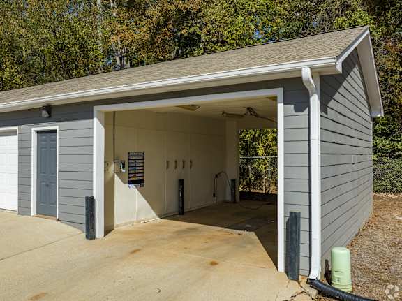 A garage with a grey siding and a white door is shown.