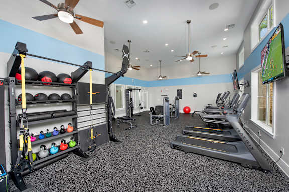 A gym with treadmills, weights, and exercise equipment.