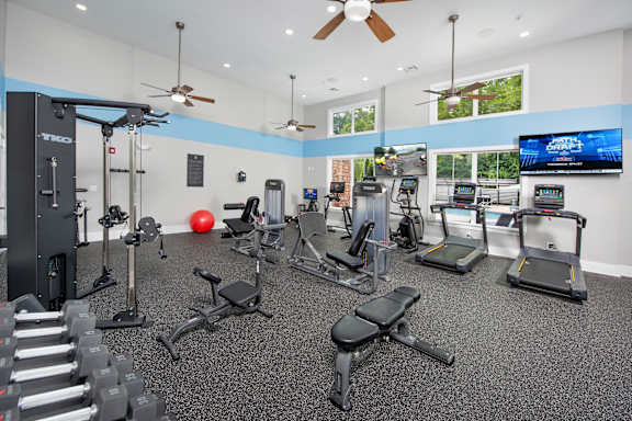 A spacious gym with a variety of equipment including treadmills, weights, and exercise machines.