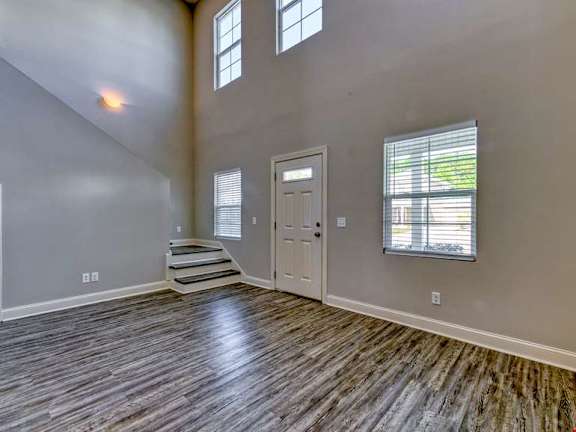 A room with wooden flooring and a white door.