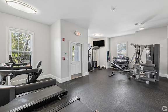 A spacious gym with treadmills, weights, and exercise equipment.