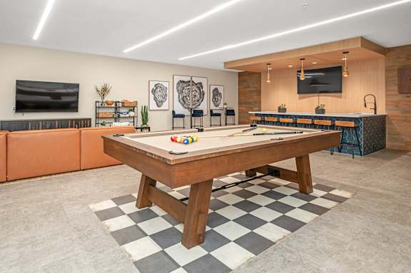 A room with a checkered floor and a wooden table in the center.