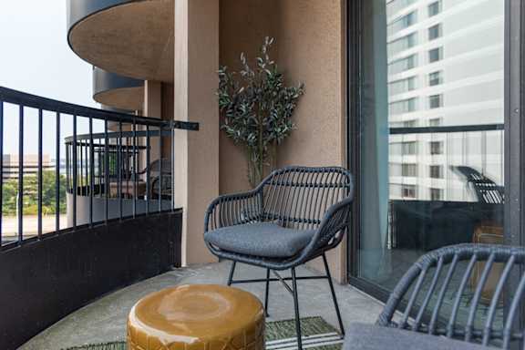 a patio with a chair and a table on a balcony