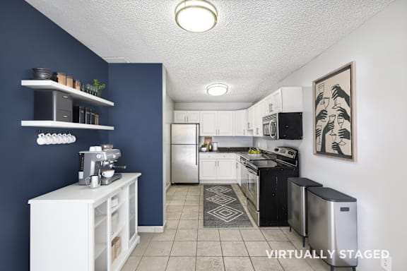 A kitchen with a blue wall and white appliances.