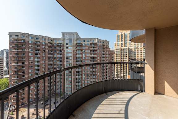 A balcony with a railing overlooks a cityscape.