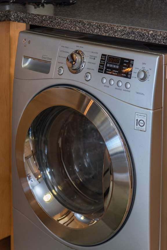 A front load washing machine with a digital display and control panel.
