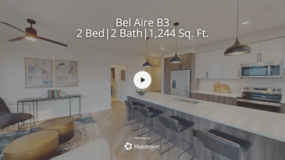 A modern kitchen with a bar stool and a fan.