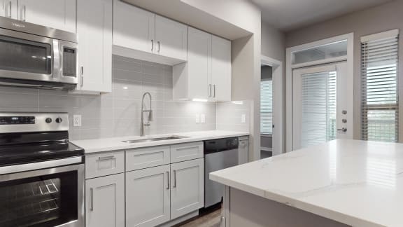a kitchen with white cabinets and a white counter top  at The Can Plant Residences at Pearl, Texas