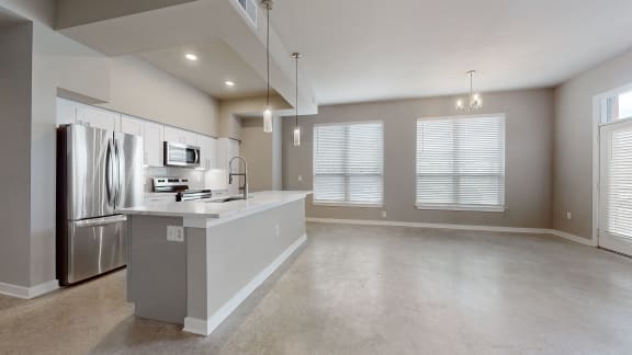 an empty kitchen with stainless steel appliances and a counter top