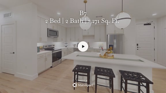 A kitchen with a bar stool in front of a counter.
