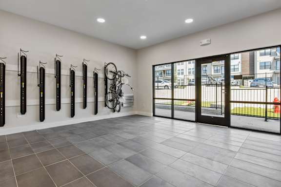 a room with bikes on the wall and a door to a balcony
