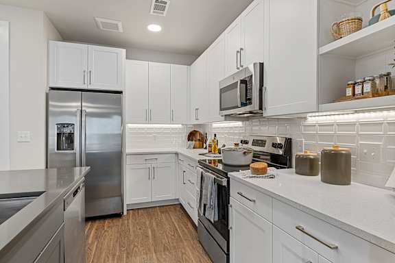 a kitchen with white cabinets and stainless steel appliances