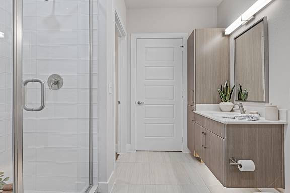 a bathroom with a shower and a sink and a mirror