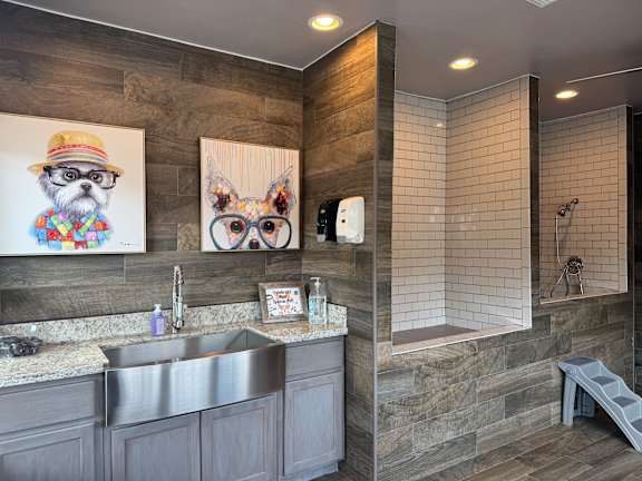 A bathroom with a grey theme and a dog picture on the wall.