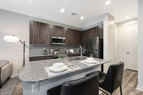 A modern kitchen with a granite countertop and black chairs, Scottsdale Hayden Townhomes, Scottsdale, Arizona