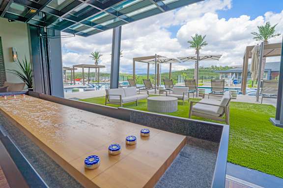 A poolside area with a wooden bench and blue and white objects on it.