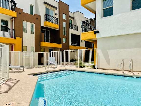 A swimming pool in front of a building with a white fence around it, Scottsdale Hayden Townhomes, Scottsdale, AZ