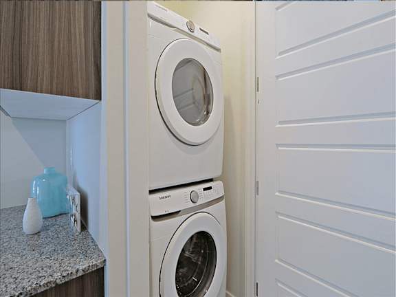 A white washing machine is stacked on top of a white dryer in a small laundry room, Scottsdale Hayden Townhomes, Scottsdale, AZ