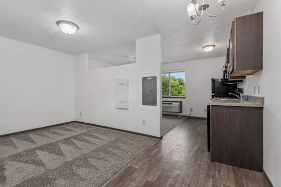 A room with a brown carpet and a wooden cabinet.