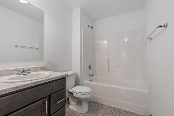 A white bathroom with a toilet, sink, and bathtub.