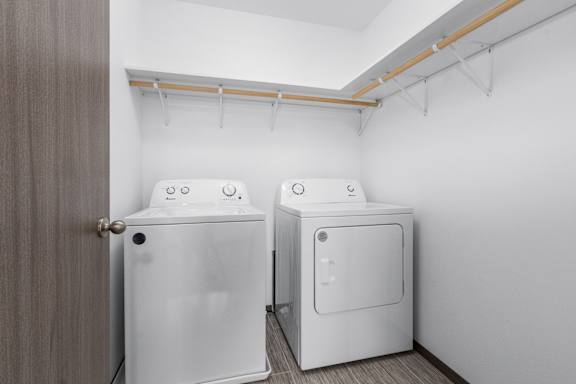 Two white washing machines in a laundry room.