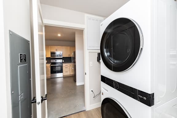 A white washing machine is in a kitchen.