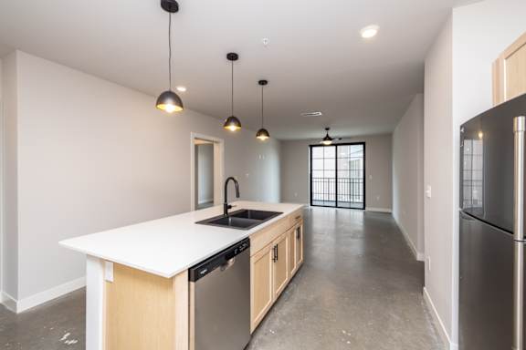 A kitchen with a white counter top and wooden cabinets.