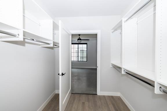 A white hallway with a door leading to a kitchen.