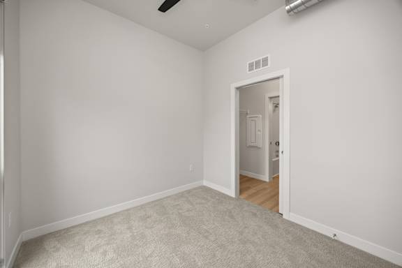 A room with a carpeted floor and a doorway leading to another room.