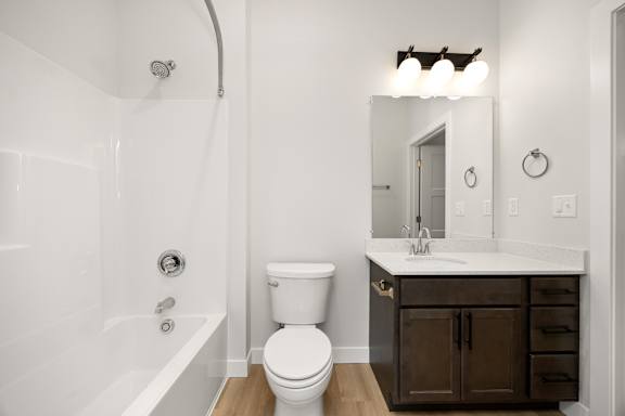 A white bathroom with a toilet, sink, and tub.