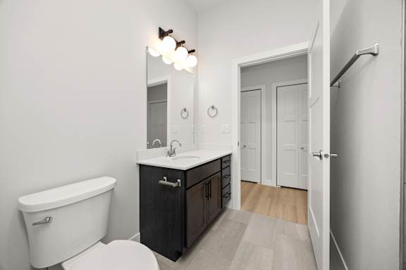 A white bathroom with a black vanity and a white bathtub.