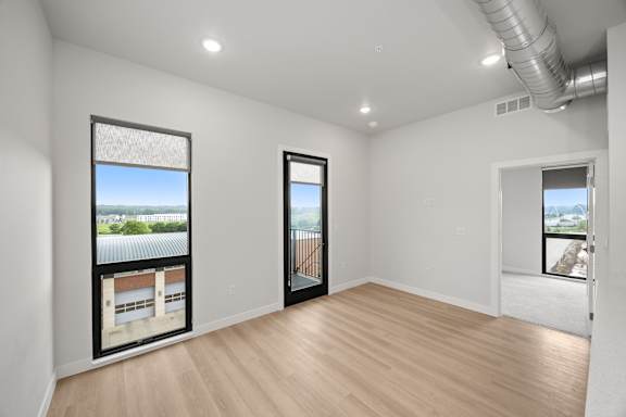 A room with a view of a building through the windows.