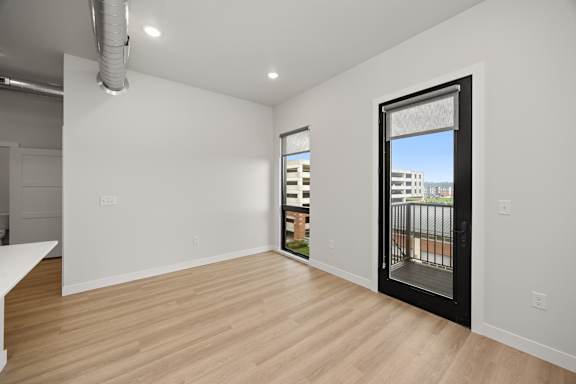 A room with a sliding glass door leading to a balcony.