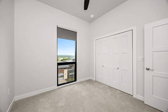 A room with a window and a ceiling fan.