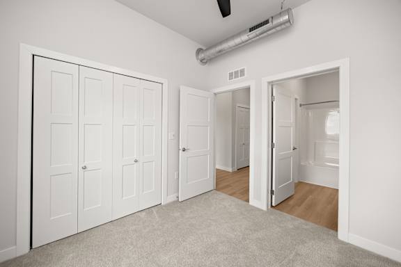 A room with white doors and a carpeted floor.
