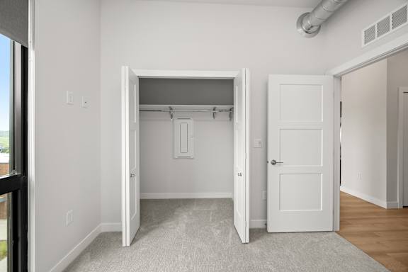 A white door is open to a room with a carpeted floor.