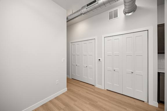 A room with white walls and a row of white doors.